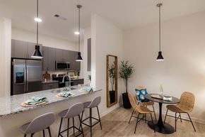 Wilmington apartment for rent - A kitchen with a bar area and a dining table with chairs at Hudson at Renaissance Apartments, Wilmington, NC