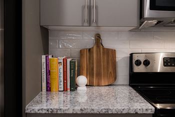 A row of cookbooks sits on a kitchen counter