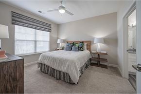Simpsonville townhouse for rent - A bedroom with a bed, two lamps, and a window with blinds at Waterleaf at Neely Ferry Apartments, Simpsonville, 29680
