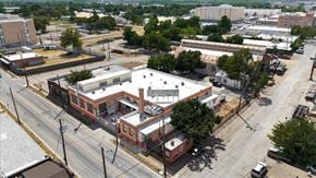 Dallas apartment for rent - A large building with a red brick exterior sits in the middle of a parking lot.