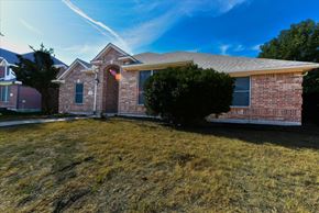 The Colony apartment for rent - A house with a red brick exterior and a large front yard.
