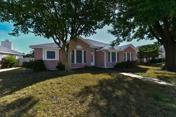 The Colony apartment for rent - A house with a red brick exterior and a large tree in front.