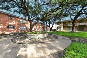Dallas apartment for rent - A courtyard with a fountain surrounded by apartment buildings.
