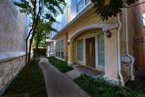 Dallas condo for rent - A yellow house with a brown door and a tree in front.