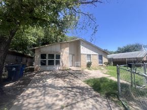 Dallas apartment for rent - A house with a driveway and a fence in front.