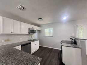 Dallas apartment for rent - A kitchen with a granite countertop and white cabinets.