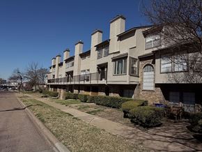Dallas condo for rent - Apartment building with a row of chimneys on the roof.