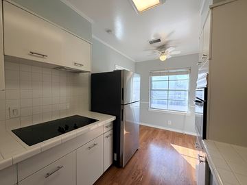 Dallas apartment for rent - A kitchen with white cabinets and a black refrigerator.