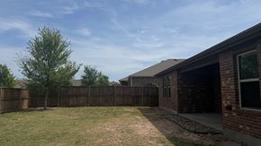 Anna apartment for rent - A backyard with a fence and a tree.