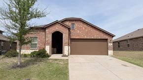 Anna apartment for rent - A brick house with a brown garage door and a tree in front.