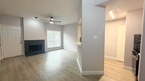 Dallas condo for rent - A spacious living room with a fireplace and a ceiling fan.