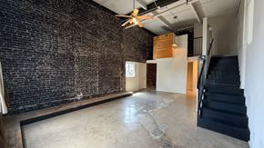 Dallas apartment for rent - A room with a brick wall and a ceiling fan.