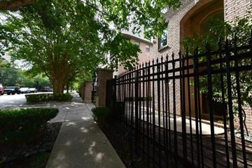 Dallas townhouse for rent - A black iron fence runs along the side of a sidewalk.