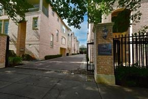 Dallas townhouse for rent - A gated entrance to a brick building with a sign that says Charles Landford.