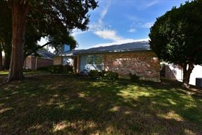 Richardson apartment for rent - A house with a lawn and trees in front of it.