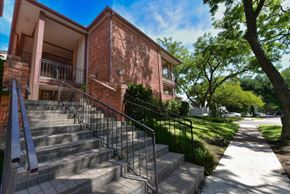 Dallas condo for rent - A red brick building with a metal railing on the stairs.