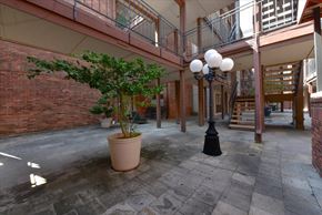 Dallas condo for rent - A courtyard with a tree, a lamp post and a potted plant.