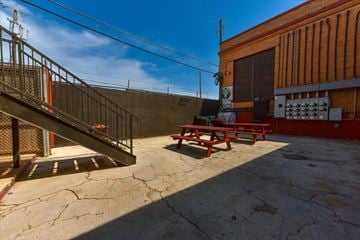 Dallas apartment for rent - A red picnic table is in front of a red building.