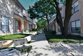 Dallas townhouse for rent - A tree-lined residential street with a sidewalk.
