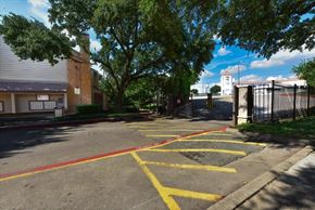 Dallas townhouse for rent - A parking lot with yellow lines and a building in the background.