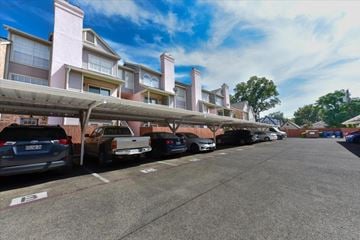 Dallas apartment for rent - A parking lot with cars parked in front of apartment buildings.