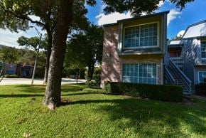 Dallas condo for rent - A tree is in front of a house.