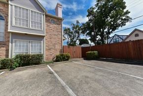Dallas apartment for rent - A brick house with a white window and a brown fence.