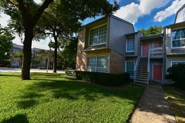 Dallas condo for rent - A tree is in front of a building.