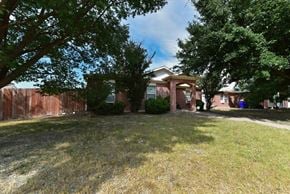 Dallas apartment for rent - A house with a red fence and green trees in front.