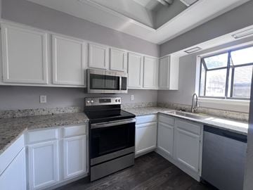 Dallas townhouse for rent - A kitchen with white cabinets and a black oven.