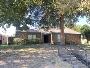 Richardson apartment for rent - A house with a tree in front and a metal fence.