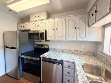 Dallas apartment for rent - A kitchen with white cabinets and stainless steel appliances.