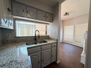 Dallas apartment for rent - A kitchen with a marble countertop and white cabinets.
