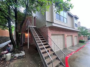 Dallas apartment for rent - A house with a red painted driveway and a garage door.