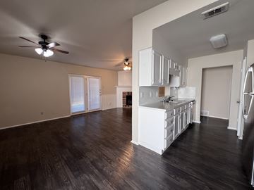 Dallas apartment for rent - A spacious kitchen with white cabinets and a dark wood floor.