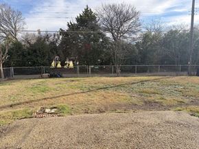 Dallas apartment for rent - A field with a fence and trees in the background.