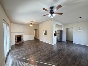 Dallas apartment for rent - A spacious living room with a fireplace and hardwood floors.