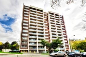 Toronto apartment for rent - A tall apartment building with a parking lot in front.