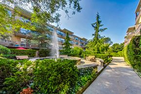 Toronto apartment for rent - a courtyard with a fountain and benches in front of an apartment building