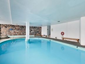 Toronto apartment for rent - a swimming pool with blue water and a stone wall