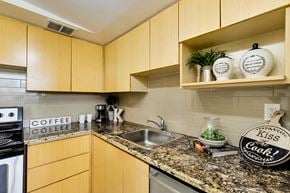 Toronto apartment for rent - A kitchen with wooden cabinets and a granite countertop.