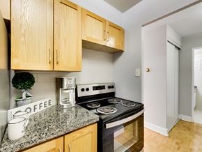 Toronto apartment for rent - A kitchen with a stove top oven and wooden cabinets.