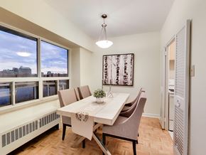 Toronto apartment for rent - A dining room with a table set for two and a view of the city.