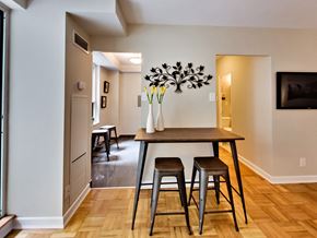 Toronto apartment for rent - a dining room with a wooden table and three stools