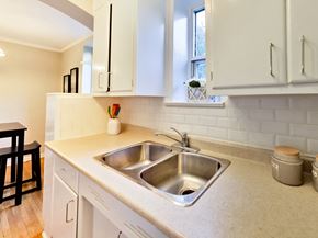 Toronto apartment for rent - a kitchen with a stainless steel sink and white cabinets