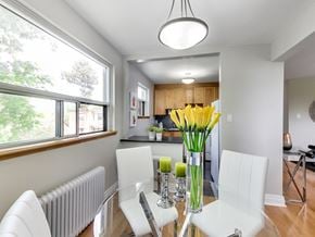Toronto apartment for rent - A dining room with a table set for two and a vase of yellow flowers.