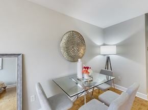 Toronto apartment for rent - A dining room with a glass table and grey chairs.