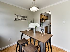 Toronto apartment for rent - A dining area with a table and chairs and a sign on the wall.