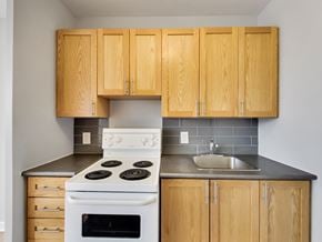 Toronto apartment for rent - an empty kitchen with white appliances and wooden cabinets