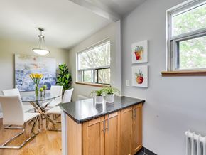 Toronto apartment for rent - A kitchen with a table and chairs and a painting on the wall.